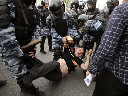 Membros da polícia prendem um dos participantes da manifestação opositora em Moscou.