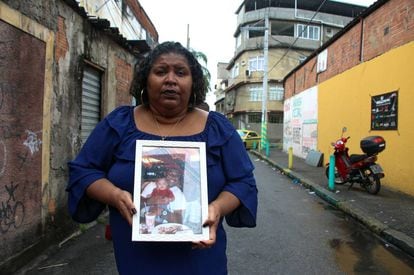 Denise de Moraes mostra uma foto de seu filho assassinado pela polícia.