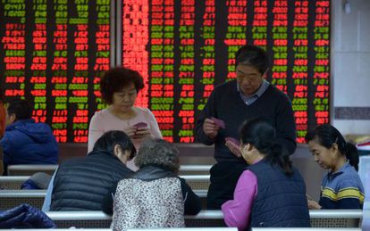 Investidores jogam baralho numa corretora de títulos em Pequim.