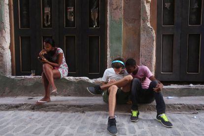 Jovens usam telefones celulares em Havana.