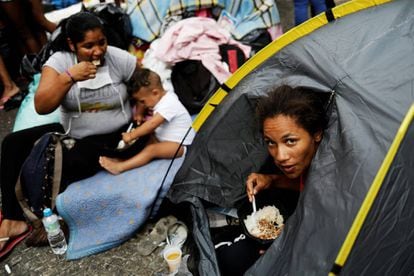 Mulher almoça no acampamento montado para receber moradores de prédio que caiu, em São Paulo.