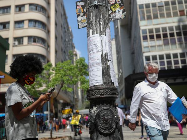 A woman writes down on her phone a job opportunity from listings posted on a light pole in downtown Sao Paulo, Brazil, September 30, 2020. REUTERS/Amanda Perobelli