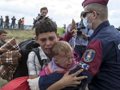 Policial húngaro barra a passagem de crianças refugiadas em Röszke (Hungria), em 8 de setembro de 2015.