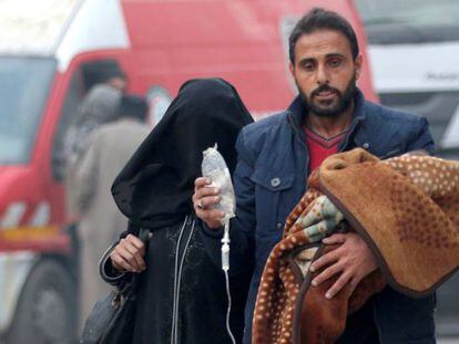 Homem evacua criança doente no leste de Aleppo