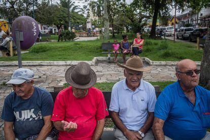 Quatro homens descansam na praça central de Eldorado.