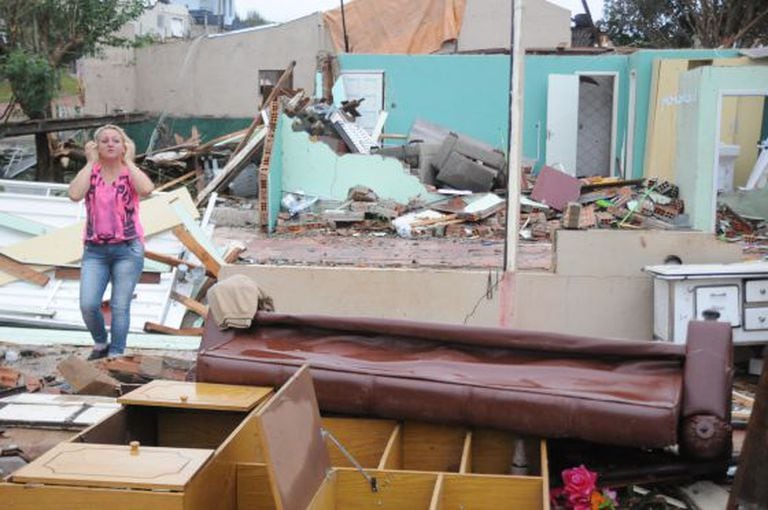 Moradora olha casa destruída após tornado em Xanxerê.
