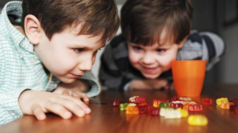 Duas crianças olhando ansiosas para doces.