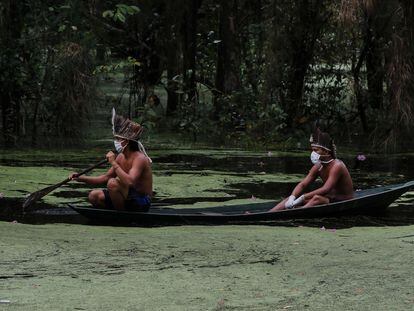 Indígenas com máscaras navegam pelo rio Ariaú, a 80 quilômetros de Manaus.