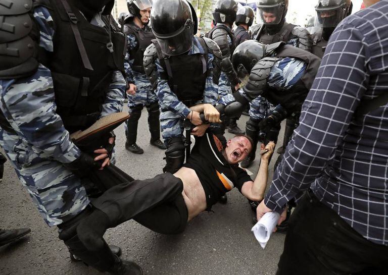 Membros da polícia prendem um dos participantes da manifestação opositora em Moscou.