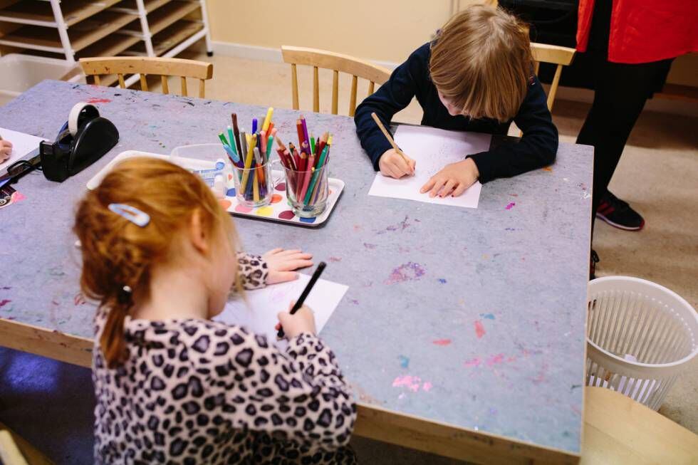 Duas crianças pintam em uma escola.