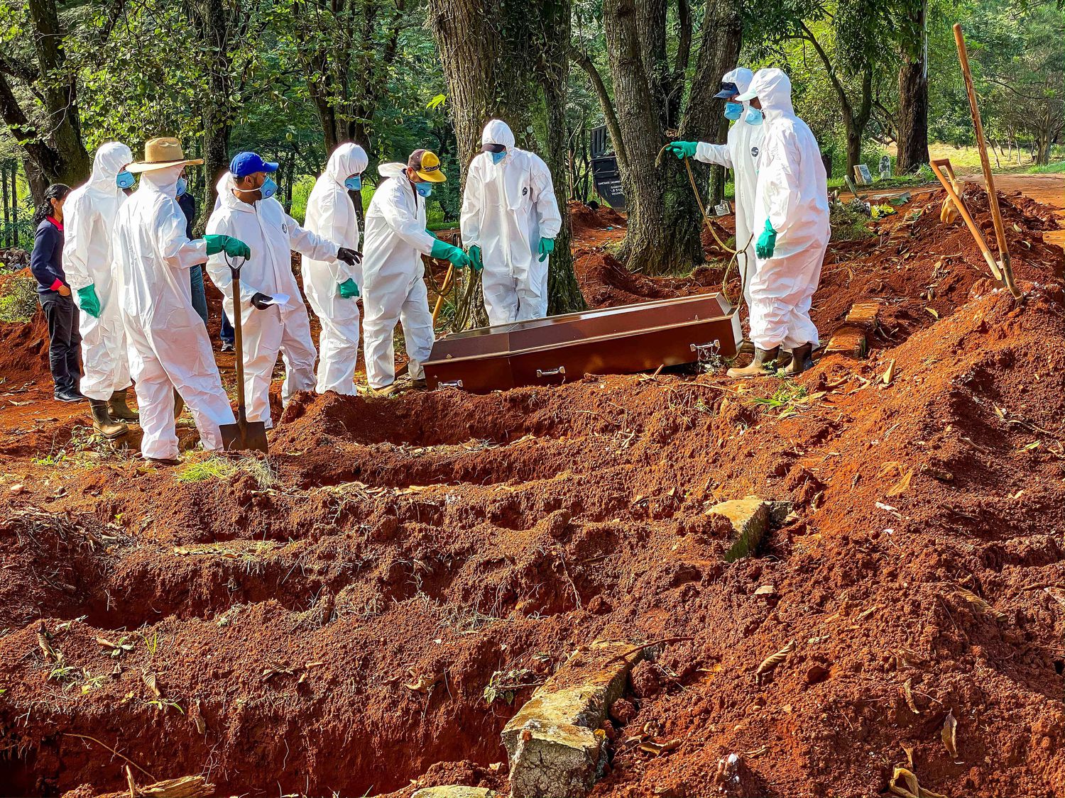 Funcionários do cemitério da Vila Formosa, em São Paulo, enterram vítima da Covid-19.