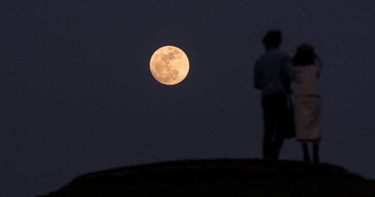 Um casal contempla a superlua na cidade de Xiamen (Chinesa).