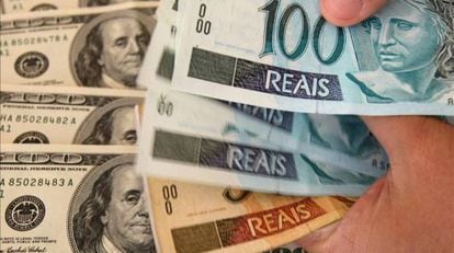 Notas de dólares norte-americanos e de reais brasileiros.