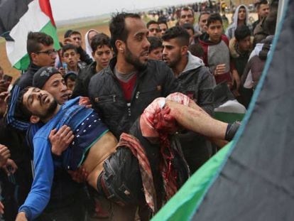 Um jovem palestino é socorrido após ter sido ferido durante uma manifestação perto da fronteira com Israel