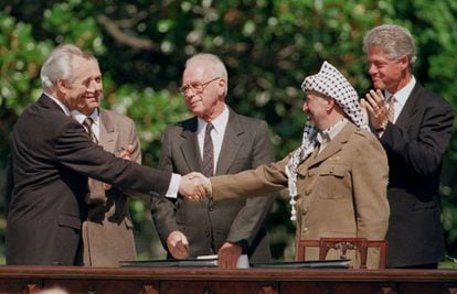 O então chanceler Shimon Peres (esq.) cumprimenta o presidente da Organização para a Libertação da Palestina, Yasser Arafat (dir.), durante a assinatura do acordo de paz do Oriente Médio de Washington, em 1993.