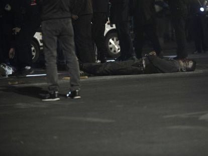 Um homem estendido no chão depois de receber um disparo da polícia.