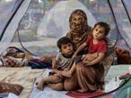 KABUL, AFGHANISTAN - AUGUST 12: Farzia, 28, who lost her husband in Baghlan one week ago to fighting by the Taliban sits with her children, Subhan, 5, and Ismael ,2,  in a tent at a makeshift IDP camp in Share-e-Naw park to various mosques and schools on August 12, 2021 in Kabul, Afghanistan. People displaced by the Taliban advancing are flooding into the Kabul capital to escape the Taliban takeover of their provinces. (Photo by Paula Bronstein/Getty Images)