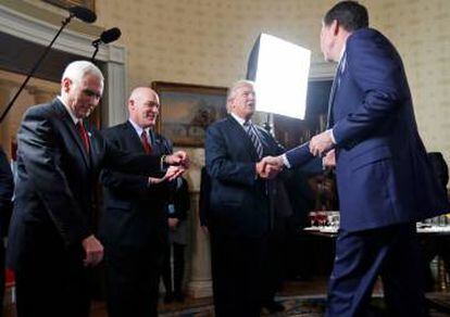 O presidente Donald Trump dá a mão ao então diretor do FBI, James Comey, na Casa Branca.
