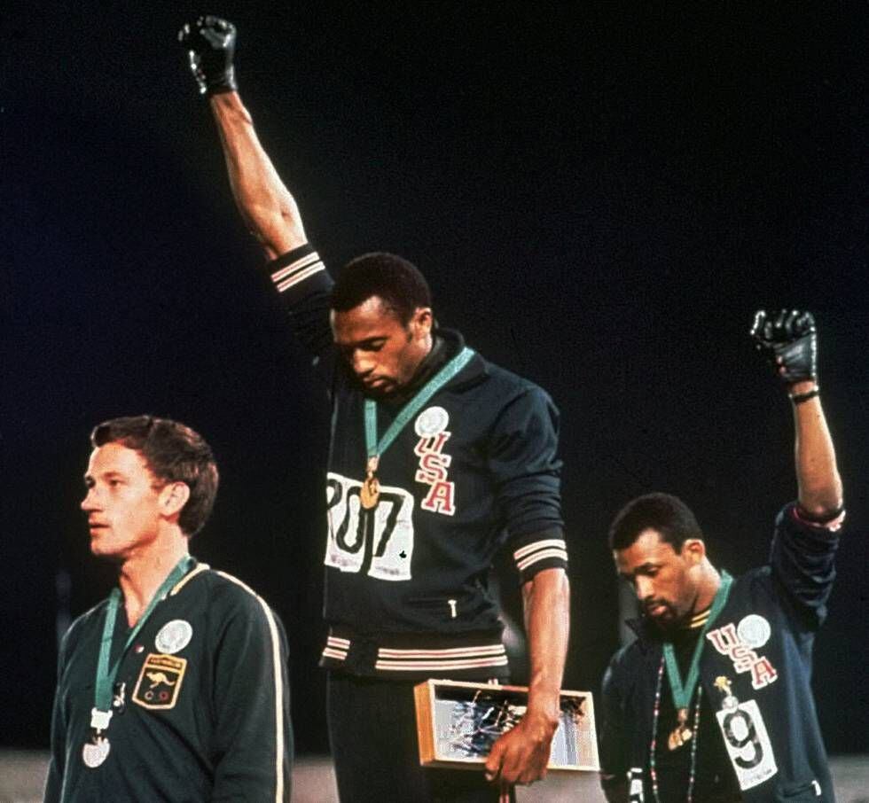 Atletas Tommie Smith (centro) e John Carlos, levantam o punho nos Jogos Olímpicos de 1968, na Cidade do México.