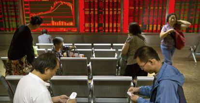 Muitos investidores acompanham as cotações em um painel da Bolsa de Pequim, que tem alta volatilidade.
