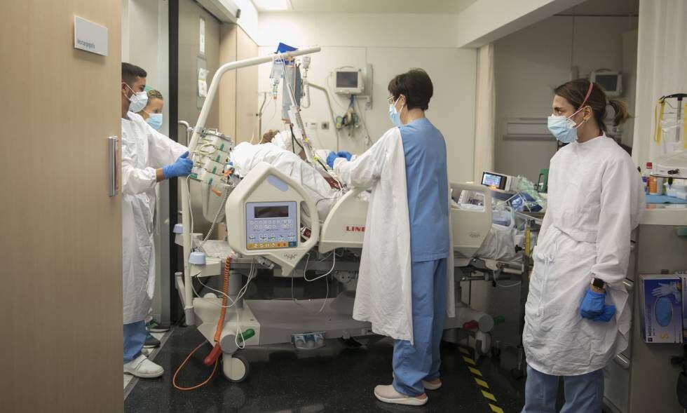 A intensivista Ana Zapatero (à direita) acompanha a paciente Raquel Txavarria a uma sala de neuroangiografia do Hospital del Mar, em dezembro. 