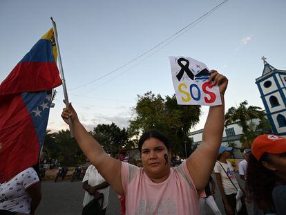 Mulher segura a bandeira da Venezuela em um protesto contra a morte em um naufrágio de migrantes venezuelanos em 17 de dezembro.