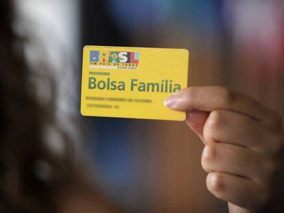 Beneficiária do programa de transferência de renda do Governo segura um cartão do Bolsa Família. 