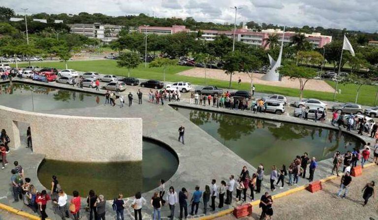 Manifestantes reunidos em torno do espelho d'água da reitoria da UFMG.