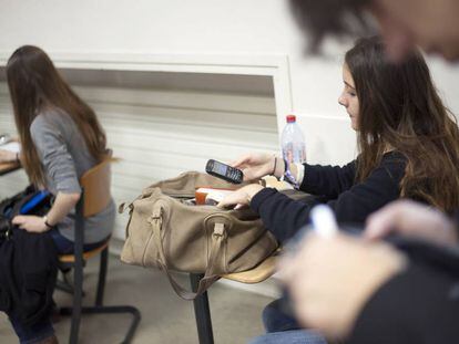 Garota francesa consulta seu celular na sala de aula.