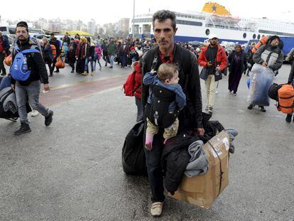 Um imigrante com um bebê chega na terça-feira a Atenas vindo das ilhas gregas.