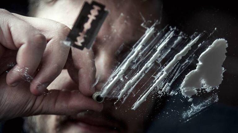 Um homem cheira cocaína.