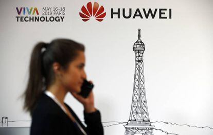 Uma mulher passa em frente a um logotipo da Huawei, neste domingo em Paris.