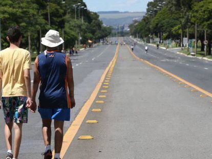 Pessoas caminham pelo Eixão, em Brasília.