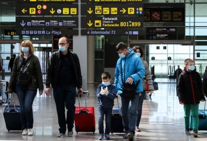 Crianças usam máscaras de proteção no aeroporto de Barcelona.