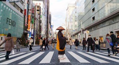 Um homem trajado de acordo com os antigos costumes cruza uma faixa de pedestres da rua Ginza, a via comercial mais cosmopolita de Tóquio