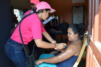 Profissionais de saúde ensinam uma mulher grávida a passar repelente contra o zika vírus em Barranquilla (Colônbia).