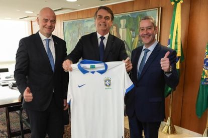 Bolsonaro entre o presidente da FIFA, Gianni Infantino, e o presidente da CBF, Rogério Caboclo, em 2019.