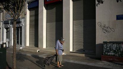 Uma mulher passa adiante de uma sucursal bancária fechada, na segunda-feira em Atenas.