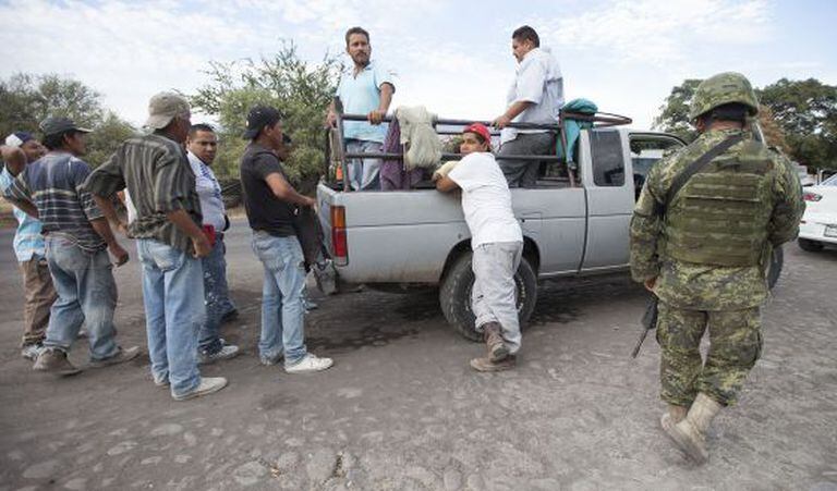 Membros do Exército mexicano inspecionam veículos na estrada que liga Apatzingán a Aguililla (Michoacán) dia 24 de janeiro.