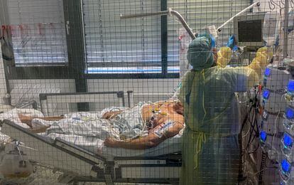 Funcionários do hospital Klinik Schwabing, em Munique, atende um paciente infectado pelo coronavírus, nesta sexta-feira.
