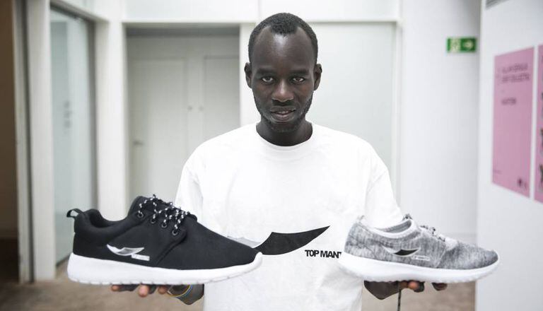 Lamine Bethily mostra alguns produtos com a marca Top Manta
