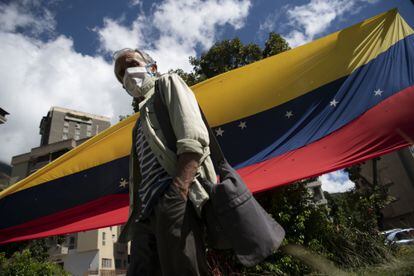 Pessoa usando uma máscara protetora caminha até uma seção eleitoral durante uma consulta liderada pela oposição no bairro de Terrazas del Ávila, em Caracas, Venezuela, no sábado, 12 de dezembro de 2020.