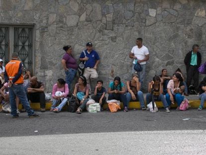 Um grupo de venezuelanos faz fila em frente a um supermercado de Caracas.