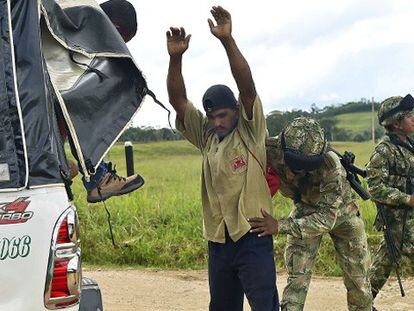 Soldados colombianos revistam um camponês.