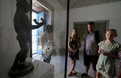 Uma família contempla, na terça-feira no Museu Nacional do Bardo, uma obra baleada durante o atentado islâmico de março passado.
