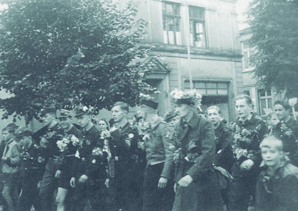 Marcha da Juventude Hitlerista em Gummersbach para intervir na Linha Siegfried, em 1944. Habermas, em primeiro plano, com flores no gorro. 