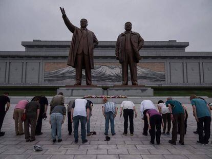 Turistas em frente a uma estátua de Kim Il-Sung (esquerda) e Kim Jong-Il (direita), em Pyongyang.