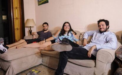María Hernández na sala de sua casa, com seus dois colegas moradia.