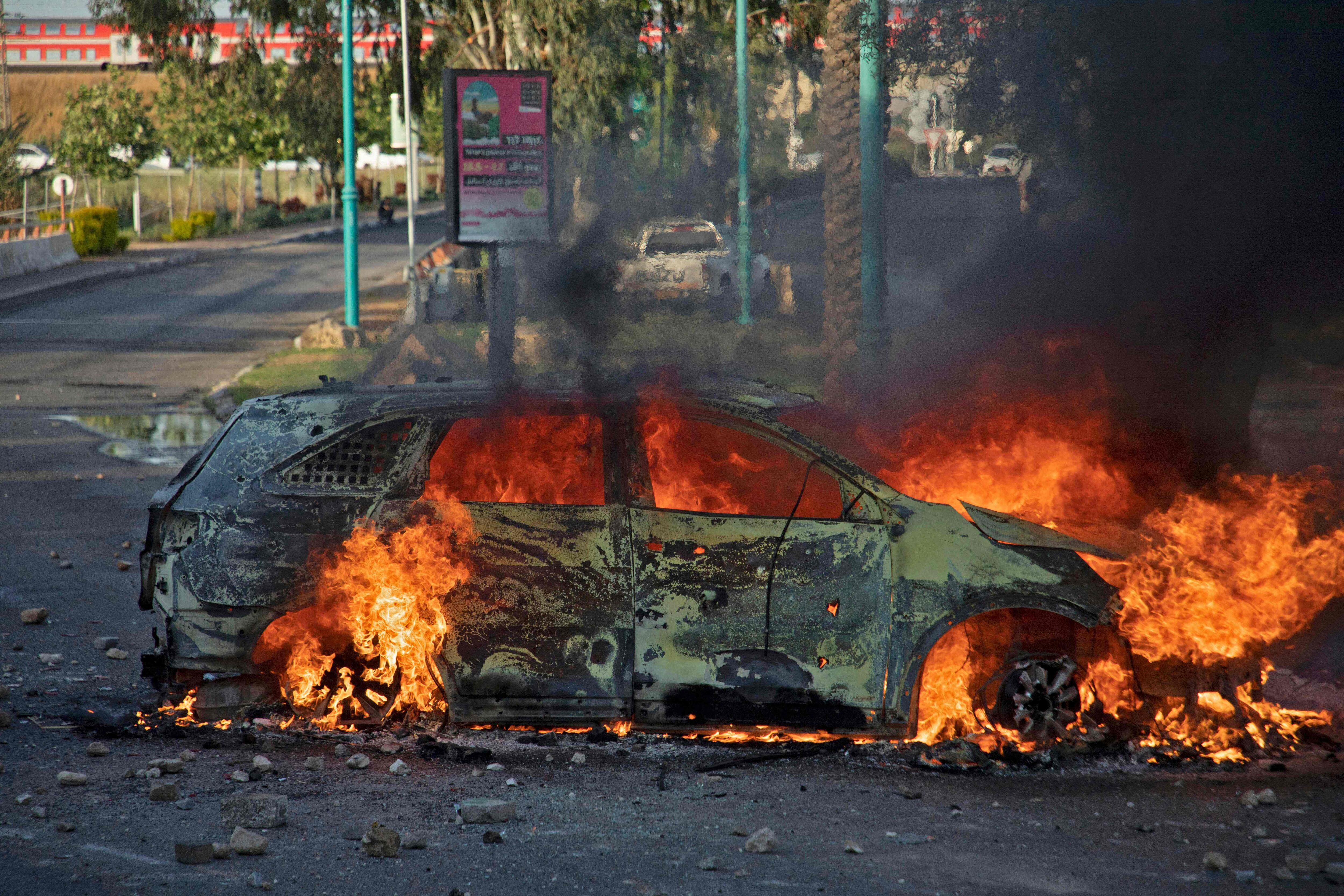 Carro da polícia israelense em chamas depois de uma manifestação contra a ofensiva de Israel, na terça-feira na cidade de Lod, ao sul de Tel Aviv.
