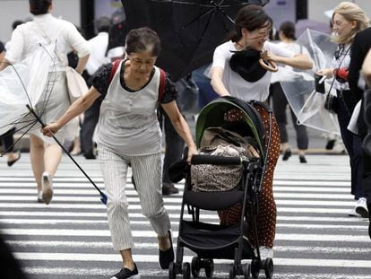 Pessoas lutam contra os fortes ventos e a chuva em Tóquio.